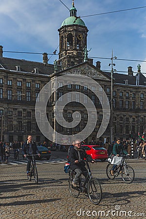 Locals biking past Royal Palace Amsterdam Editorial Stock Photo