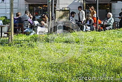 Locals relax and drink coffee at a restaurant patio on a sunny morning Editorial Stock Photo