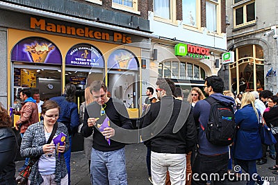 Locals and tourist at Amsterdam's famous Manneken pis dutch fries Editorial Stock Photo