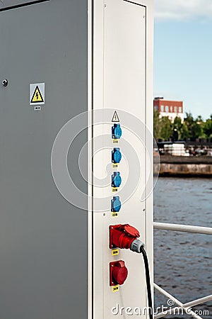Locked electric panel with attention sign on great wall of transformer substation. High voltage sign. Electrical sockets Stock Photo