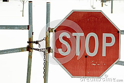 Locked gate with a stop sign Stock Photo