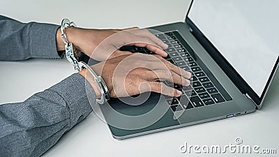 Locked hands, handcuffs, and playing laptop computers Stock Photo
