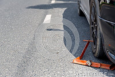 Locked wheel of a car parked in an improper place. Car wheels locked, traffic violation. Black car get locked up by the police. Stock Photo