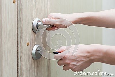 Locking up or unlocking door with key in hand. Stock Photo