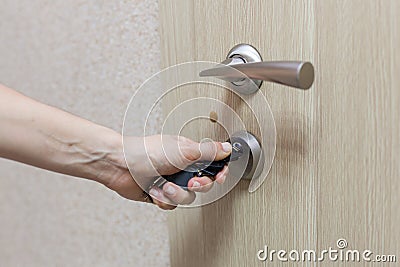 Locking up or unlocking door with key in hand. Stock Photo