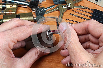 Locksmith inserts key in cylinder lock Stock Photo