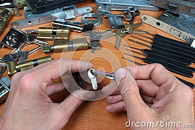 Locksmith inserts key in cylinder lock Stock Photo