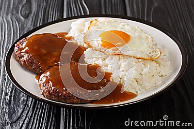 Loco moco is a Hawaiian cuisine made with white rice with a hamburger patty, sunny side up egg, and brown beef gravy close-up on a Stock Photo