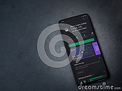 Mimo - Learning coding app play store page on the display of a black mobile smartphone on a dark marble stone background Editorial Stock Photo