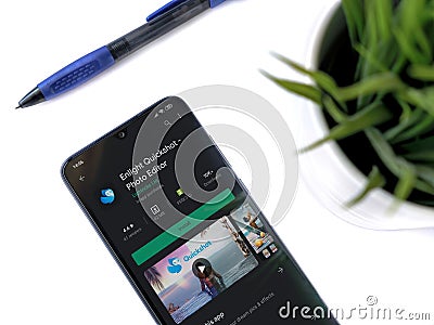 Office workspace with smartphone with Enlight Quickshot app play store page on white background Editorial Stock Photo