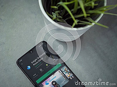 Office workspace with smartphone with Enlight Quickshot app play store page on marble background Editorial Stock Photo