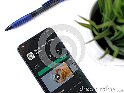 Office workspace with smartphone with VSCO - Photo and Video Editor app play store page on white background Editorial Stock Photo