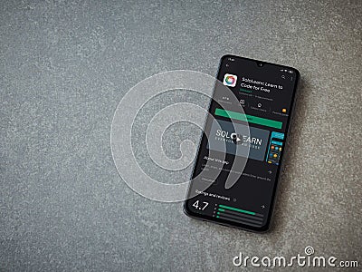 SoloLearn - Learning coding app play store page on the display of a black mobile smartphone on ceramic stone background Editorial Stock Photo
