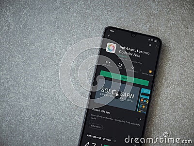SoloLearn - Learning coding app play store page on the display of a black mobile smartphone on ceramic stone background Editorial Stock Photo