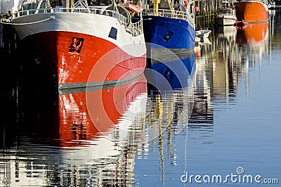 Lofoten - colorful boats reflecting in clear water, Norway Stock Photo