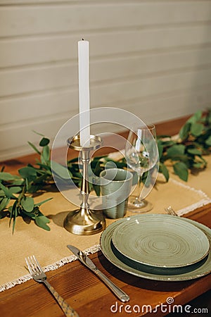 The loft dining table is decorated with flowers, candles and herbs. Soft selective focus Stock Photo