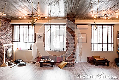 Loft room for fitness and relaxation, relaxation with brick walls and windows, gym, tea. Stock Photo