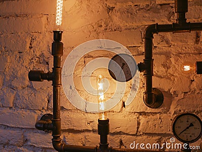 Loft style decor With iron pipes. and incandescent lamps. Loft style wall and steampunk pipes Stock Photo