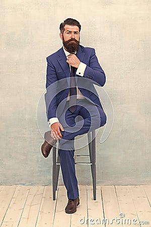 With lofty ambitions. Brutal man in elegant suit. Bearded man with formal look. Hipster sit on chair. Man with mustache Stock Photo