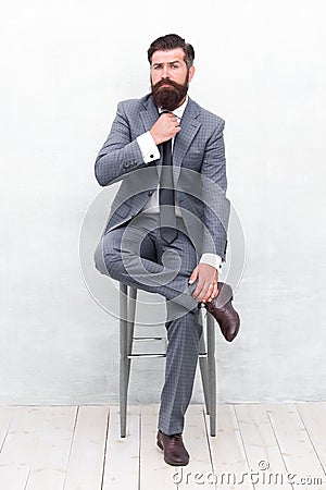 With lofty ambitions. Brutal man in elegant suit. Bearded man with formal look. Hipster sit on chair. Man with mustache Stock Photo