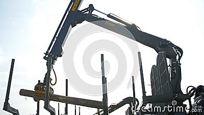 Log loader or forestry machine moves fresh cut logs for loading Editorial Stock Photo