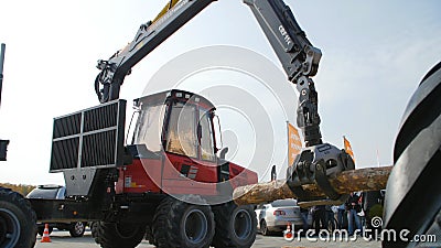 Log loader or forestry machine moves fresh cut logs for loading Editorial Stock Photo