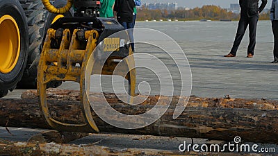 Log loader or forestry machine moves fresh cut logs for loading Editorial Stock Photo