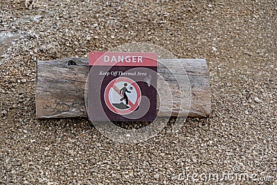 A log with a warning sign warns tourists and visitors to stay out of the thermal areas of the park Editorial Stock Photo