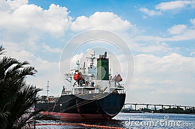 Logistic concept, black Ship parked in the river. Stock Photo