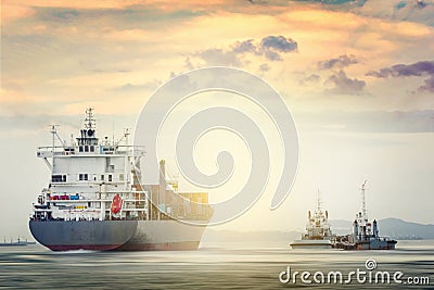 Logistics and transportation of International Container Cargo ship with tugboat in the ocean at sunset time, Freight Stock Photo