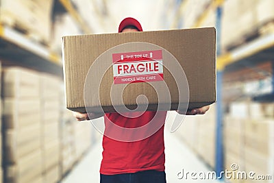 Logistics warehouse worker holding package with fragile items Stock Photo