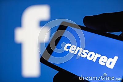 Logo of the Facebook blurred on background. The concept of censorship on popular social networks. Shallow DOF Editorial Stock Photo