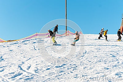 Logoisk. Belarus. 01.03.2023. A group of children snowboarders with a coach descend from a snow-covered mountain Editorial Stock Photo