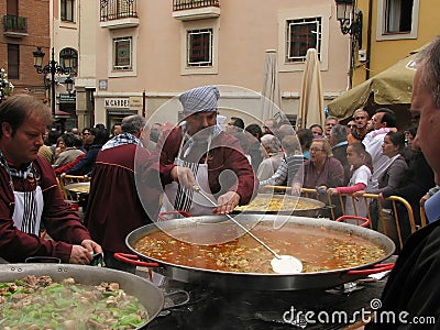 Chefs cooking paella, a typical dish of Valencia, during the festivities of San Mateo. Queue of people waiting for their turn. Editorial Stock Photo