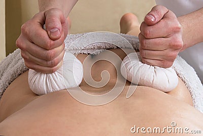 Loins massage with herbal bags Stock Photo