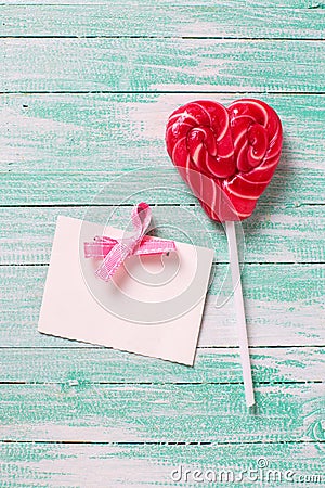 Lollipop candy heart and empty tag on turquoise wooden backgro Stock Photo