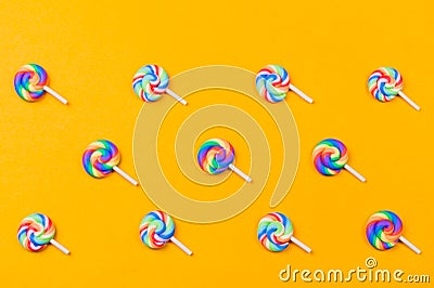 Lollipops are in a row. spiral candy pattern. lots of sweets on a yellow background. festive decoration Stock Photo