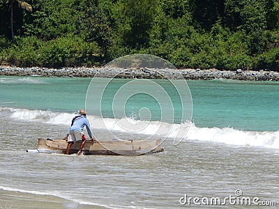 LOMBOK, INDONESIA - CIRCA 2014: A fisherman takes his boat out into the sea on the island of Lombok in indonesia Editorial Stock Photo