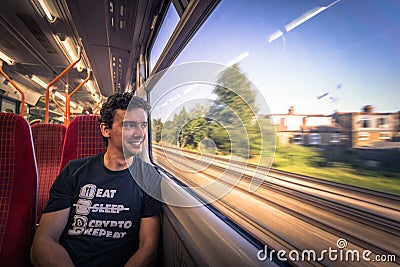 London - August 05, 2018: Young man traveling on a train in London, England Editorial Stock Photo