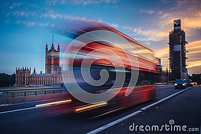 London. Classic red double decker bus crossing Westminster Bridge at sunset Editorial Stock Photo