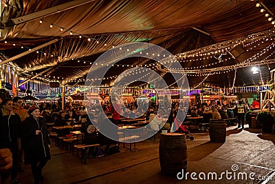 LONDON, ENGLAND, DECEMBER 28, 2018: People enjoying a pleasant time in a Christmas market, surrounded by food and drink stands, Editorial Stock Photo