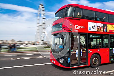 English double-decker bus crossing westminster bridge with the ferris wheel `the london eye` in the distance Editorial Stock Photo