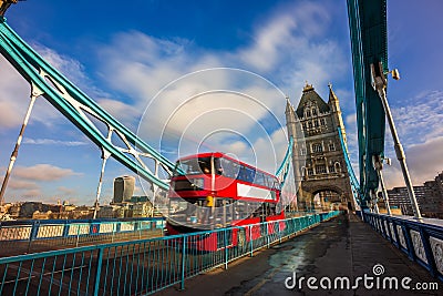 London, England - Iconic red double-decker bus in motion on famous Tower Bridge Stock Photo