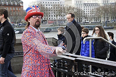 London, England: 8th March 2018: A man dressed in British flag jacket and sunglasses and a `London` hat selling tickets outside Editorial Stock Photo