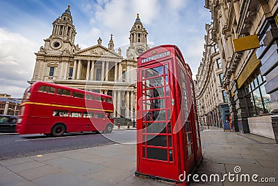 London, England - Traditional red telephone box with iconic red vintage double-decker bus on the move Stock Photo