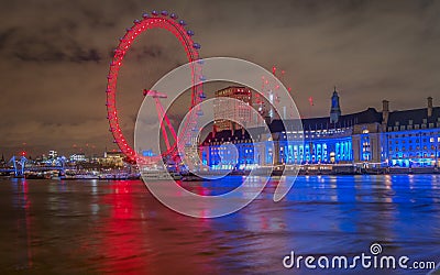 Enjoying a lovely view of the London eye lit with colorful lights at night from the westminster bridge Editorial Stock Photo