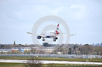 A British Airways Airbus A320-232 callsign G-MIDX comes in to land at Gatwick Airport, with the Lowfield Heath church spire Editorial Stock Photo