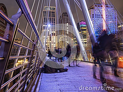 London 11/21/2019: Homeless asking for money with people in background that ignore him. The number of homeless on the streets is Editorial Stock Photo