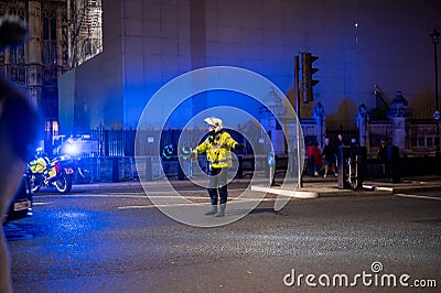A Police motorcyclist directs traffic outside The Houses of Parliament during The Million Mask March Editorial Stock Photo
