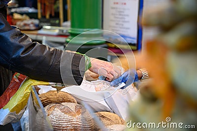 A customer paying for loaves of bread at a bread stall in Borough Market, London Editorial Stock Photo